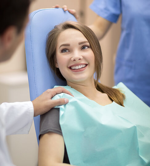 smiling teenage girl sitting in a dental chair