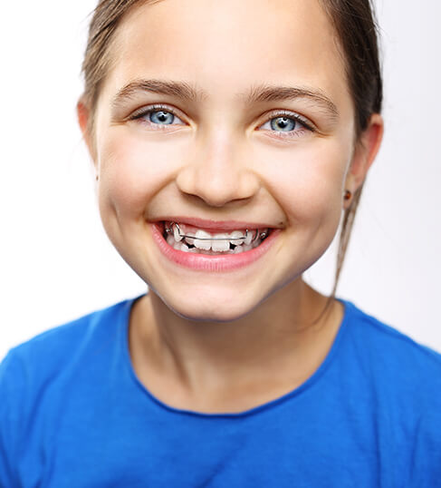 smiling young girl with a metal retainer