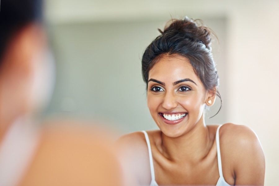 woman with straight teeth and straight smile thinking of benefits of straight teeth
